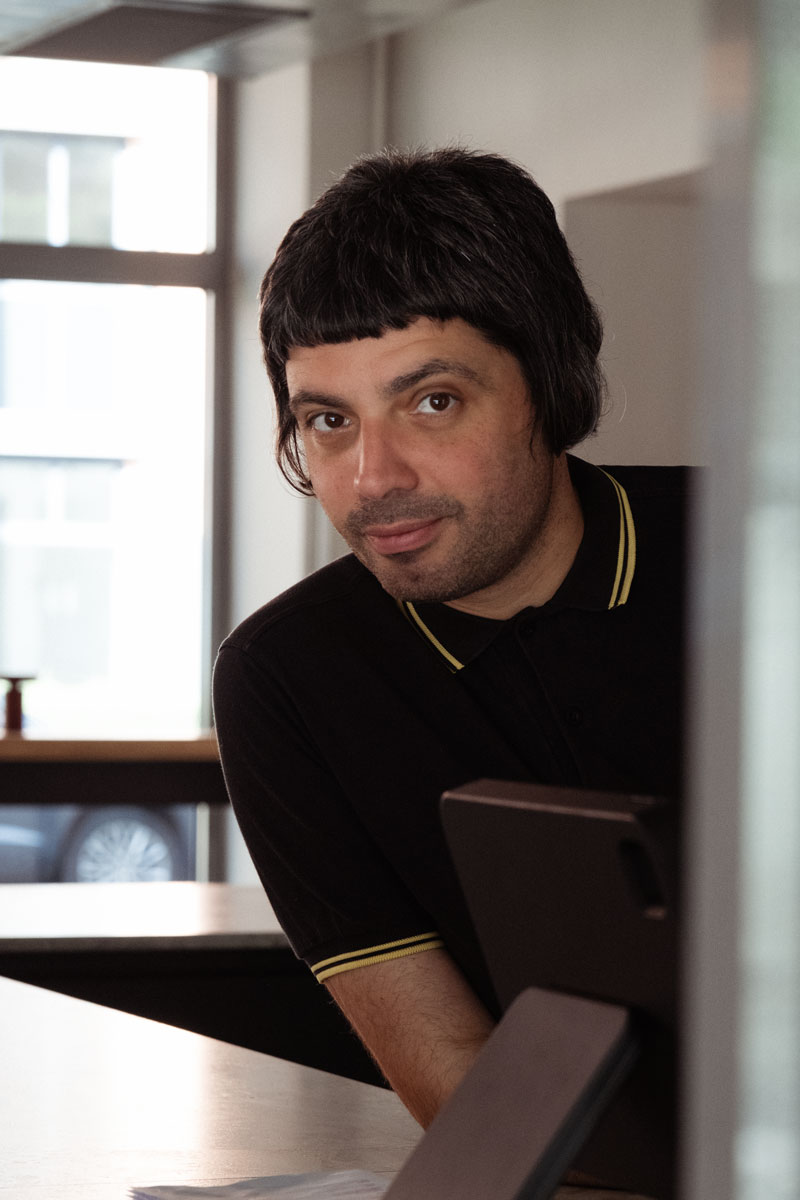 Porträtbild Mann mit kurzen braunen Haaren und braunen Augen.